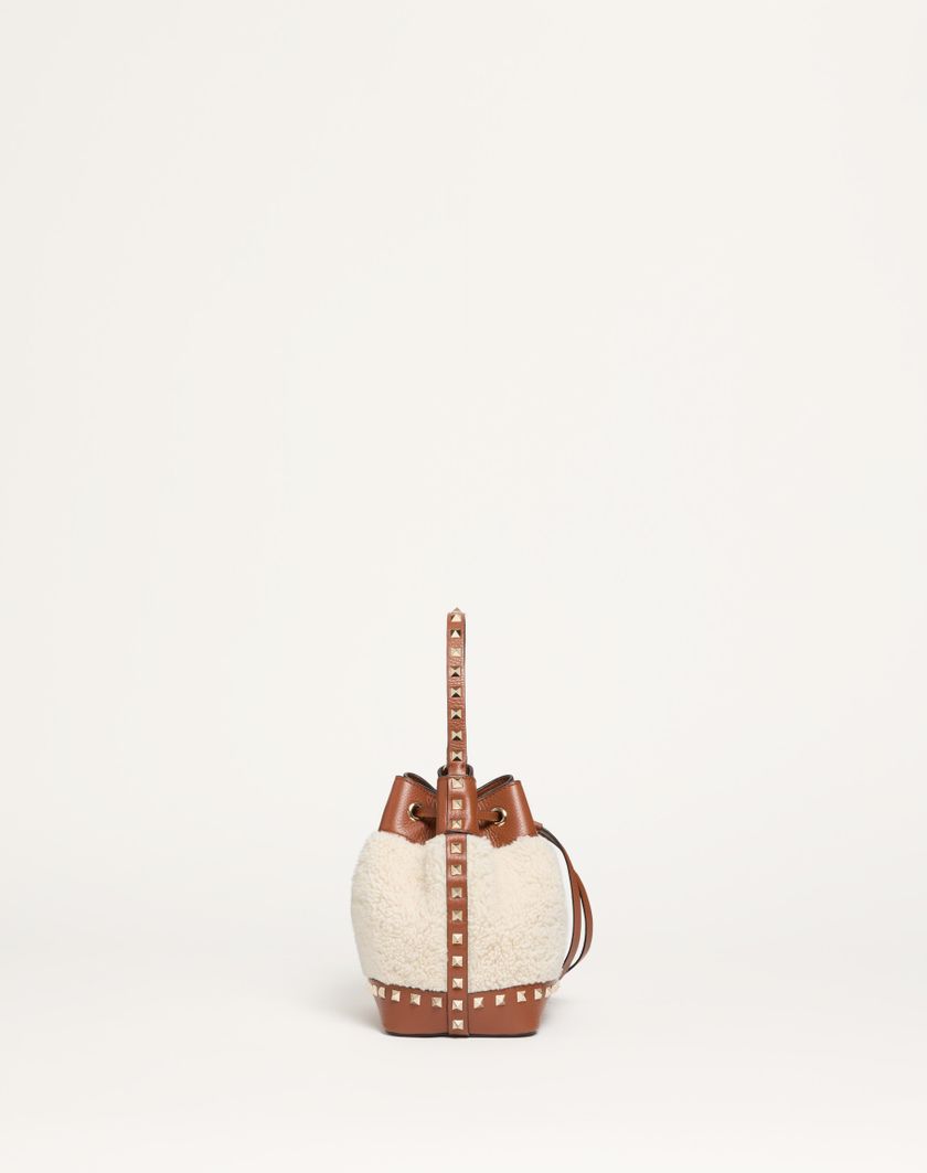 Valentino Handbags Borsa A Secchiello Valentino Garavani Rockstud In Shearling Per Donna In Naturale/selleria | Valentino IT